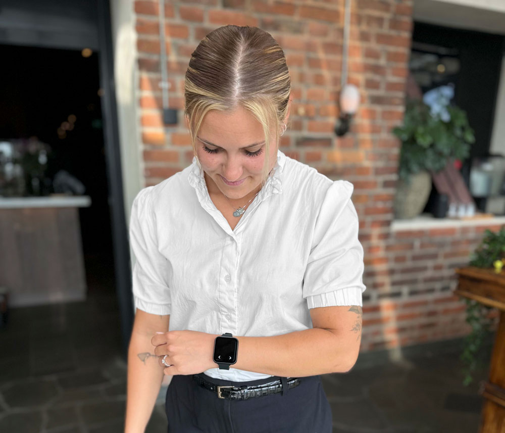 A Click Service bracelet on a waitresses arm